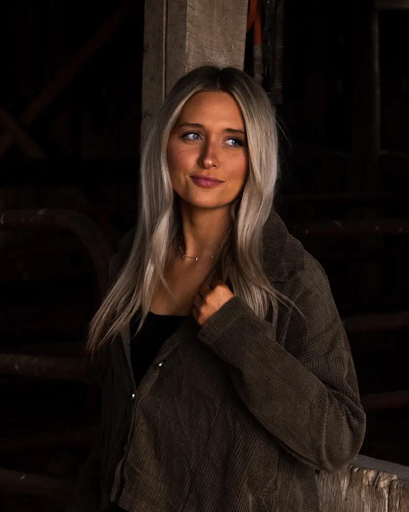 Kacie in an olive corduroy jacket in the barn